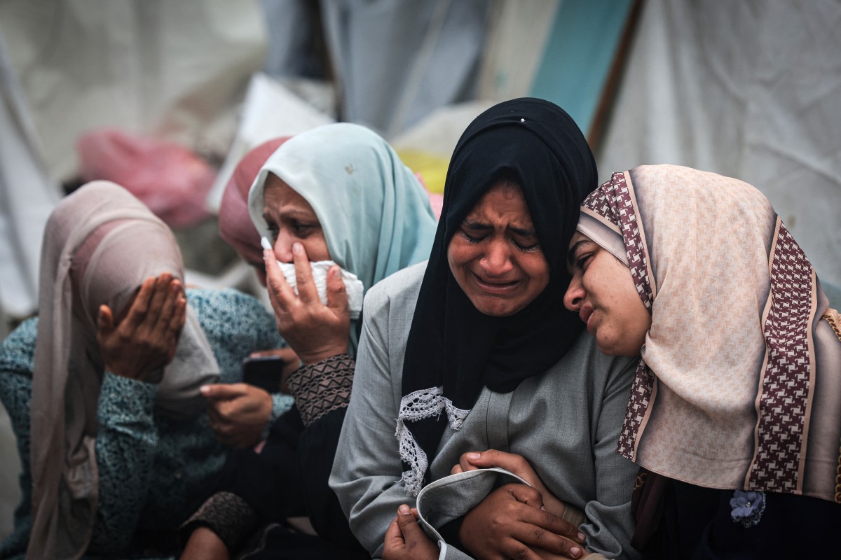 Palestinians mourn their relatives, killed in an overnight Israeli strike on the Al-Maghazi refugee camp, during a mass funeral at the Al-Aqsa hospital in Deir Al-Balah, in the central Gaza Strip, on December 25, 2023. Photo by MAHMUD HAMS / AFP