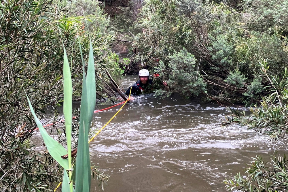 This handout photo taken and released by the Victoria Police on December 27, 2023 shows an emergency worker during a rescue operation in the midst of flood waters after heavy rain at the Buchan campground in east Gippsland, located east of Melbourne in the Australian state of Victoria. Photo by Handout / VICTORIA POLICE / AFP