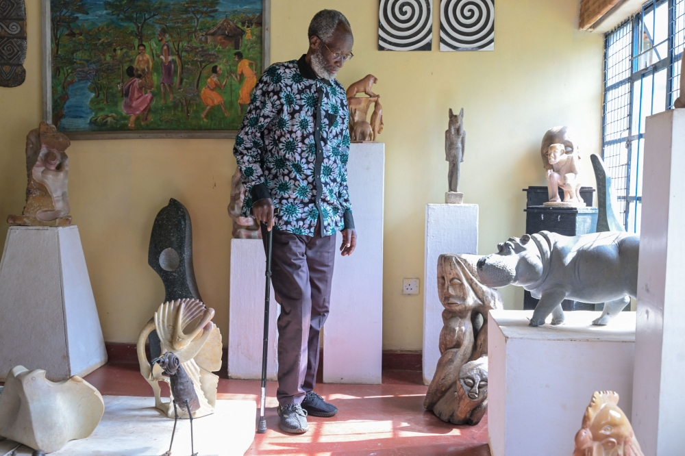 Kenyan stone sculptor Elkana Ong'esa walks surrounded by some of his sculptures at the Elkana Ong'esa Museum (ELKOM) in Kisii on November 29, 2023. (Photo by Simon Maina / AFP)