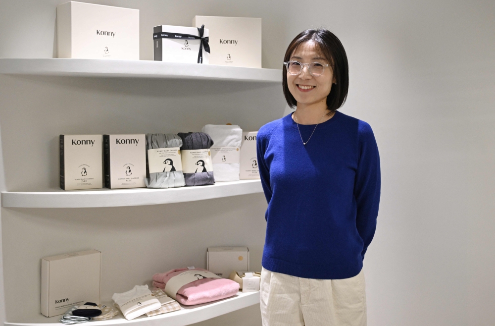 This picture taken on November 29, 2023 shows Erin Lim, CEO of baby products company Konny, posing with baby goods after an interview with AFP at her company's new office in Seoul. Photo by Jung Yeon-je / AFP