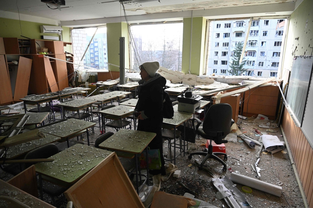 A teacher inspects her classroom that was damaged after a missile attack in Lviv, western Ukraine, on December 29, 2023, amid the Russian invasion of Ukraine. (Photo by Yuriy Dyachyshyn / AFP)