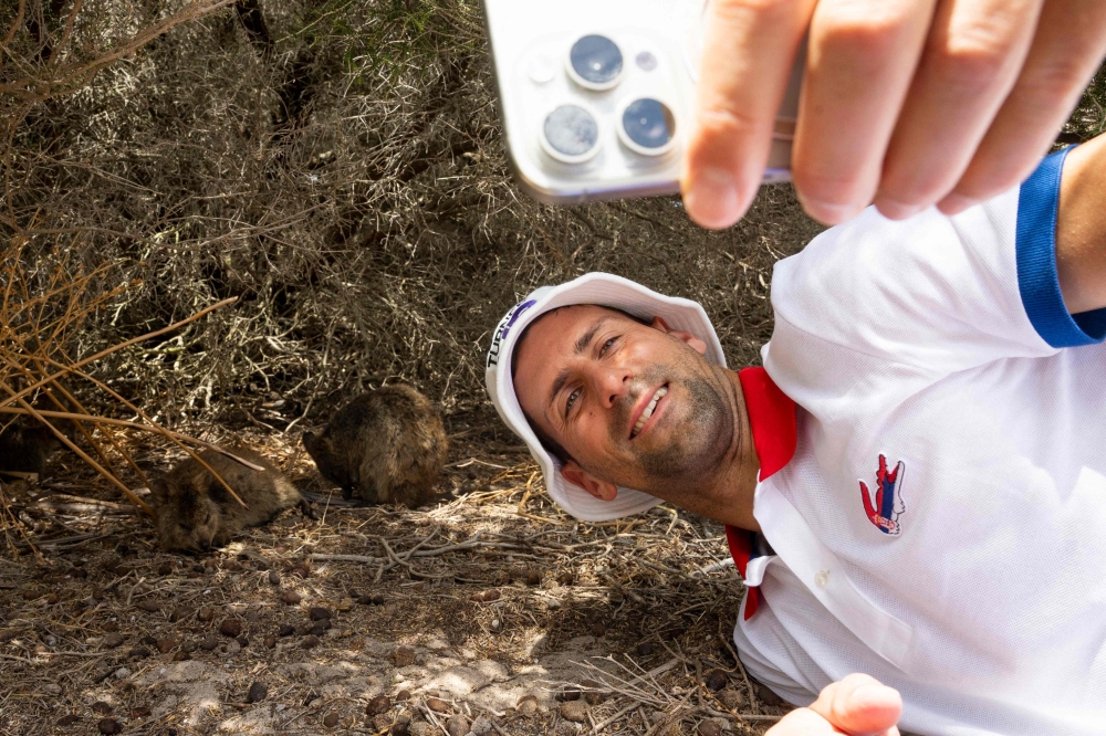 Handout photo taken on December 29, 2023 and released on December 30 shows Serbia's Novak Djokovic taking a selfie with quokka on Rottnest Island ahead of the 2024 United Cup tennis tournament in Perth. (Photos by Matt Jelonek / Tennis Australia / AFP)