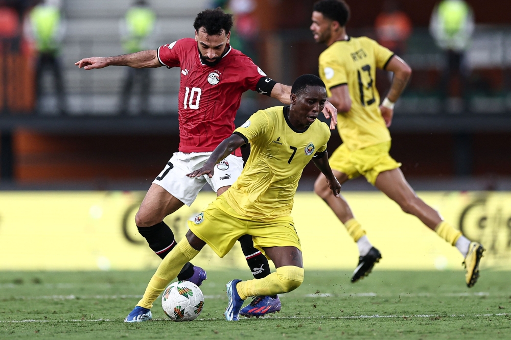 Egypt's forward #10 Mohamed Salah (L) fights for the ball with Mozambique's midfielder #7 Elias Pelembe (C) during the Africa Cup of Nations (CAN) 2024 group B football match between Egypt and Mozambique at the Felix Houphouet-Boigny Stadium in Abidjan on January 14, 2024. (Photo by FRANCK FIFE / AFP)
