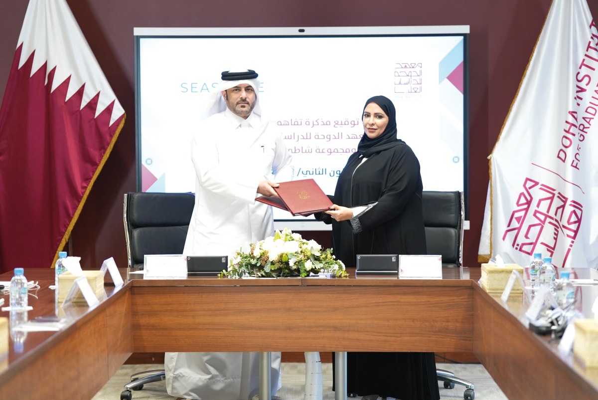 Executive Director of the Administrative and Financial Division at the DI Eman bin Abdulla Alsulaiti (right) and Vice-Chairman of Seashore Group Saqr Saeed Almohannadi exchanging documents after signing the agreement.