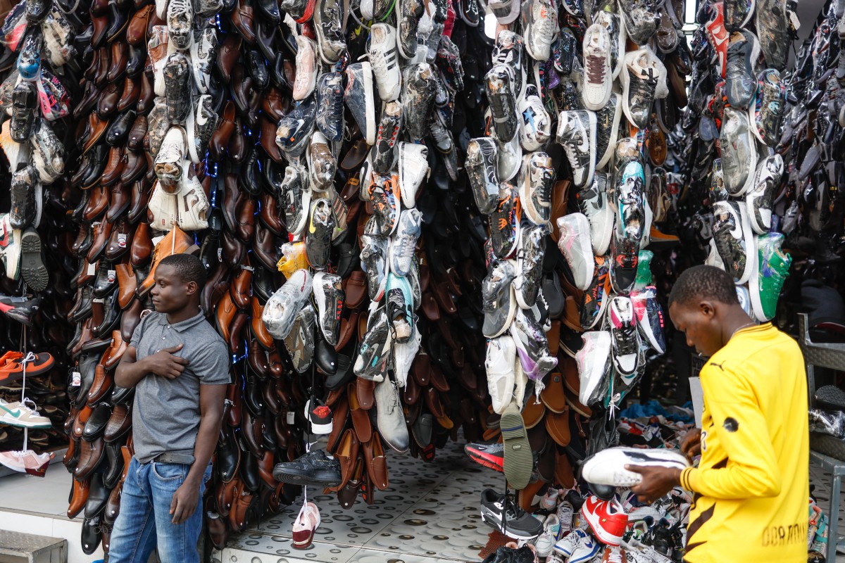 Pedestrians shop for shoes along the business district in Nairobi, on January 16, 2024. (Photo by SIMON MAINA / AFP)
