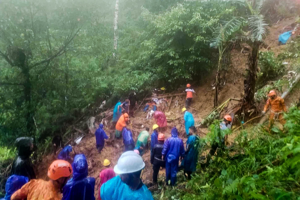 This handout photo taken and released by the Municipality of Monkayo on January 18, 2024 shows rescuers conducting a rescue and retrieval operation, a day after a landslide hit a house in Monkayo, where at least seven people were killed, a disaster official said, with the death toll expected to rise. Photo by Handout / Municipality of Monkayo / AFP