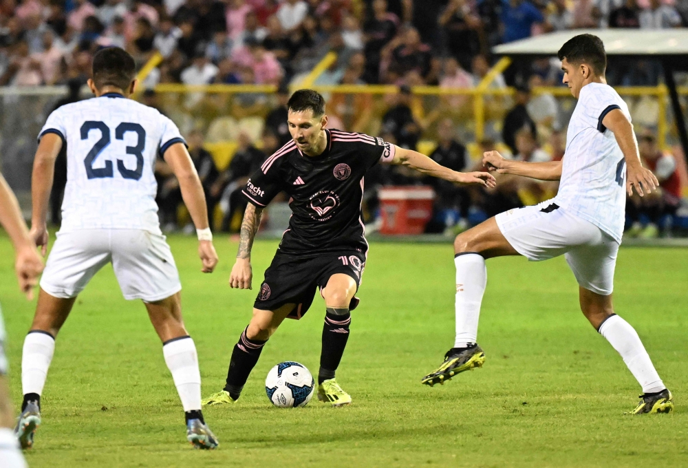 Inter Miami's Argentine forward #10 Lionel Messi vies for the ball with El Salvador's midfielder Melvin Cartagena #23 and El Salvador's defender #02 Julio Sibrian in San Salvador, El Salvador, on January 19, 2024. (Photo by Marvin Recinos / AFP)