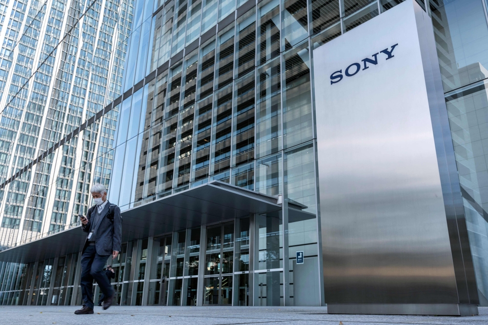 This file photo taken on October 31, 2022 shows a man walking past the Sony logo outside the company's headquarters in Tokyo. Photo by Richard A. Brooks / AFP