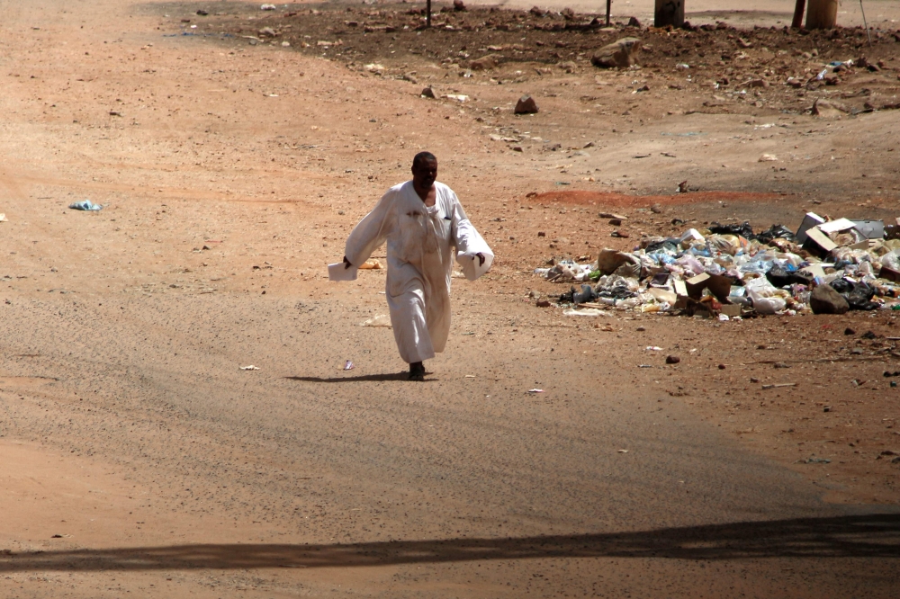 A man walks down a road in Khartoum amid ongoing fighting between the forces of two rival generals, on May 18, 2023. (Photo by AFP)

