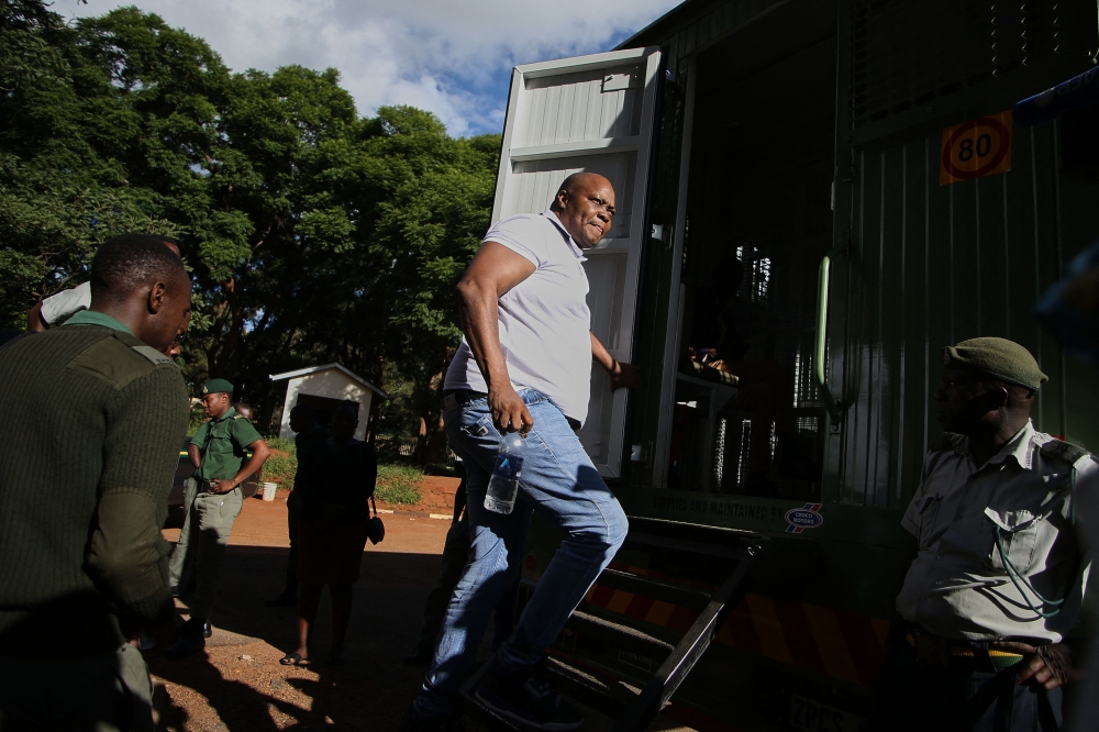 Zimbabwe former legislator and prominent member of the opposition party Citizens Colaition for Change (CCC) Job Sikhala climbs into a prisons truck at the Harare Magistrates Court in Harare on January 24, 2024 after the court convicted him of inciting public violence. (Photo by Jekesai NJIKIZANA / AFP)
