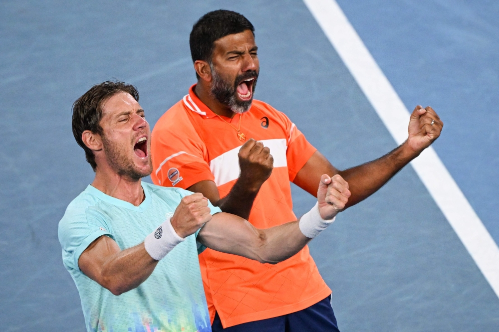 India's Rohan Bopanna (R) and Australia's Matthew Ebden celebrate after victory against Italy's Simone Bolelli and Andrea Vavassori during their men's doubles final match on day 14 of the Australian Open tennis tournament in Melbourne on January 27, 2024. (Photo by WILLIAM WEST / AFP)