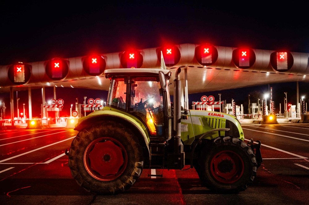 Protesting farmers blockade the A10 highway with tractors during a protest against taxation and declining income, near the Peage de Saint-Arnoult-en-Yvelines toll gates southwest of Paris, on January 26, 2024, as part of a nationwide day of protests called by several farmers unions on pay, tax and regulations. (Photo by Dimitar DILKOFF / AFP)
