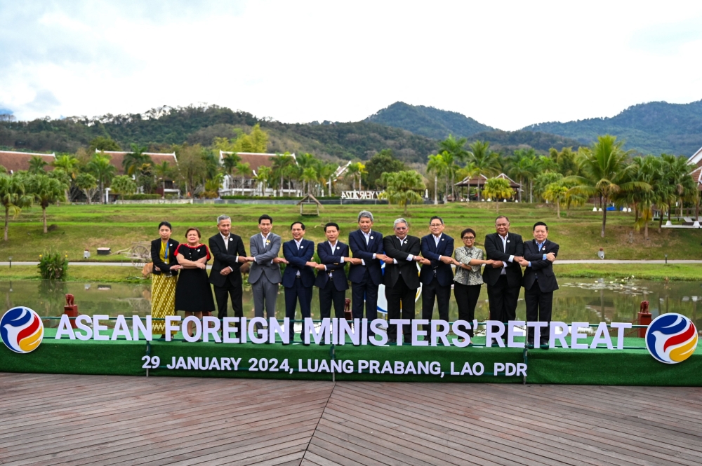 (L-R) Myanmar Permanent secretary Marlar Than Htaik, Undersecretary Philippine Som leader Theresa P. Lazaro, Singapore's Foreign Minister Vivian Balakrishnan, Thailand's Foreign Minister Parnpree Bahiddha-Nukara, Vietnam's Foreign Minister But Thanh Son, Laos' Foreign Minister Saleumxay Kommasith, Malaysia's Foreign Mohamad Hasan, Brunei's Foreign Minister Erywan Pehin Yusof, Cambodia's Foreign Minister Sok Chenda Sophea, Indonesia's Foreign Minister Retno Marsudi, East Timor's Foreign Minister Bendito dos Santos Freitas and ASEAN Secretary General Kao Kim Hourn pose for a group photo during the ASEAN Foreign Ministers' meeting in Luang Prabang on January 29, 2024. (Photo by TANG CHHIN SOTHY / AFP)