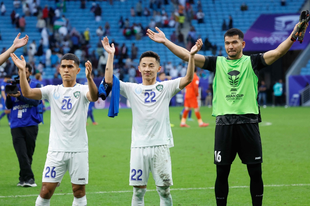 Uzbekistan's players celebrates with their fans after the Qatar 2023 AFC Asian Cup football match between Uzbekistan and Thailand at Al-Janoub Stadium on January 30, 2024. (Photo by Karim Jaafar / AFP)