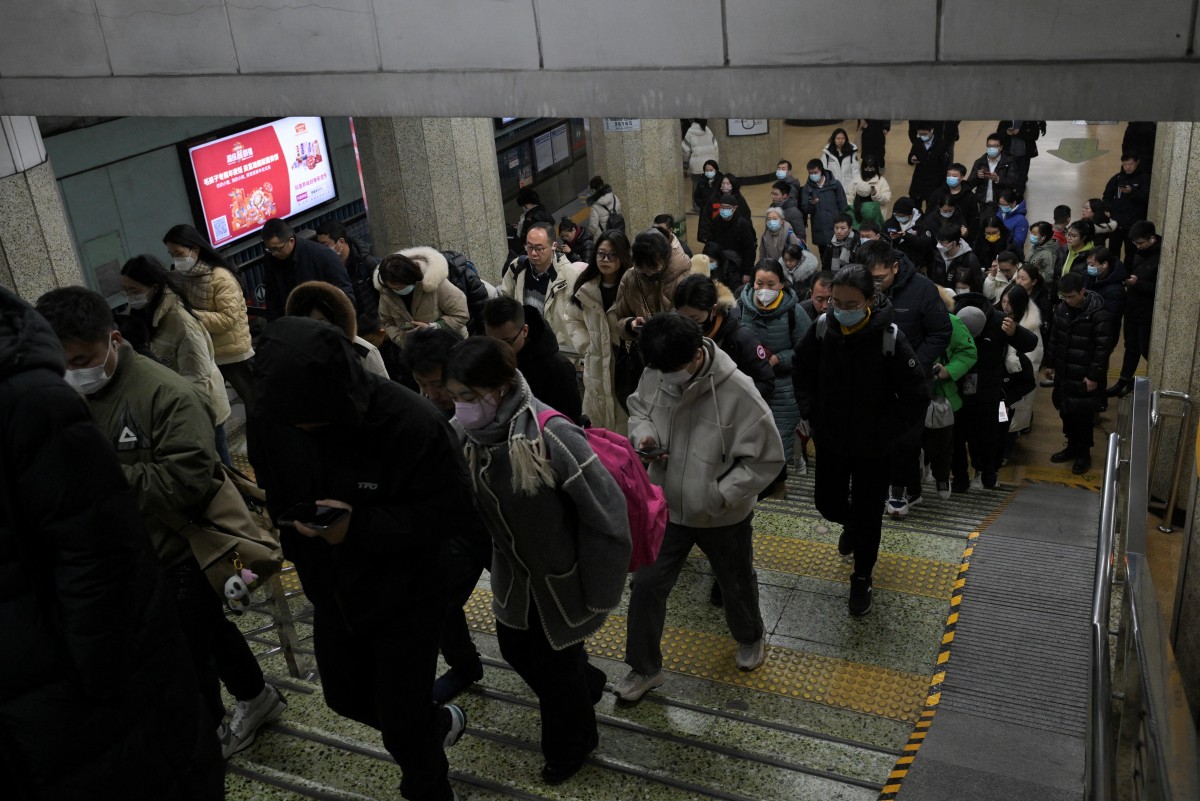 People are seen at a subway station in Beijing on January 17, 2024. Photo by Pedro PARDO / AFP