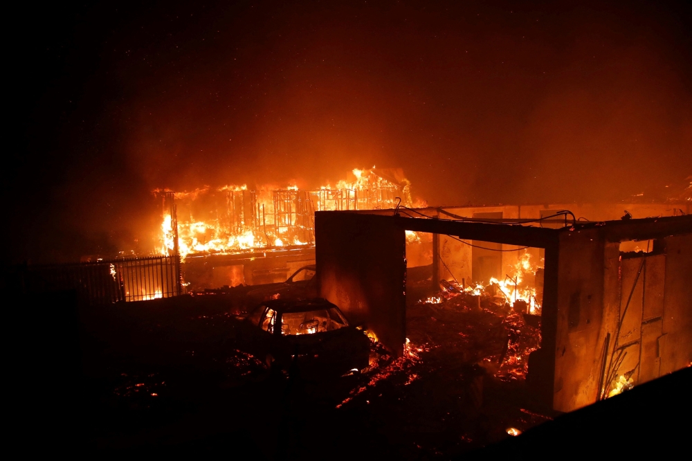 Vehicles and homes burn during a fire in Viٌa del Mar, Chile, on February 2, 2024. (Photo by Javier Torres / AFP)
