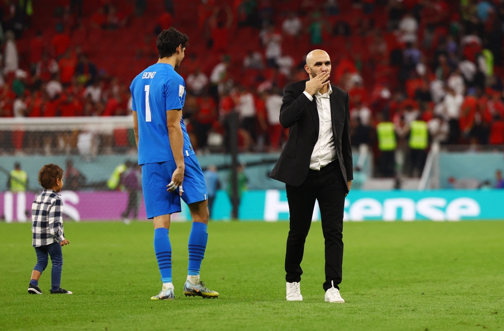 Morocco coach Walid Regragui and Yassine Bounou celebrate after the match as Morocco progress to the semi finals of the FIFA World Cup Qatar 2022 at the Al Thumama Stadium in Doha on December 10, 2022. REUTERS/Kai Pfaffenbach