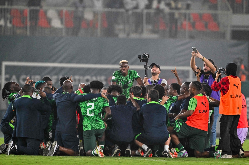 Nigeria's forward #9 Victor Osimhen (C) and teammates celebrate the victory at the end of the Africa Cup of Nations (CAN) 2024 semi-final football match between Nigeria and South Africa at the Stade de la Paix in Bouake on February 7, 2024. (Photo by Issouf SANOGO / AFP)
