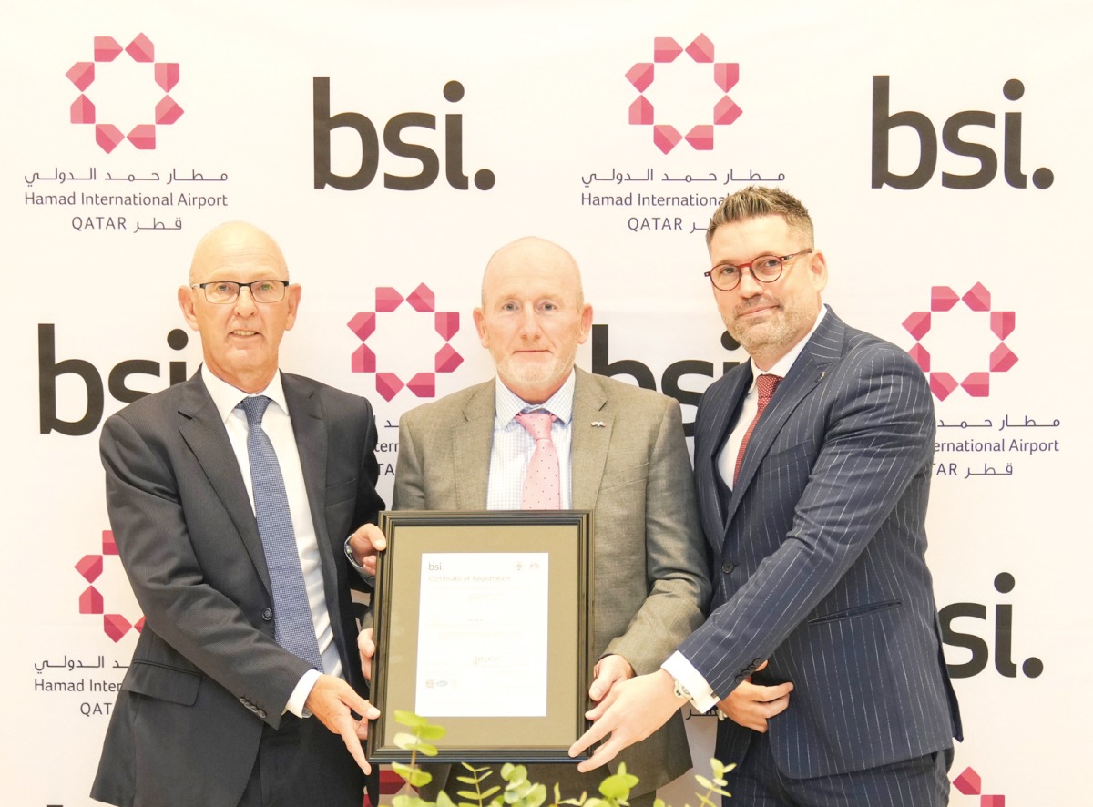 Hamad International Airport officials showcasing the award from BSI.