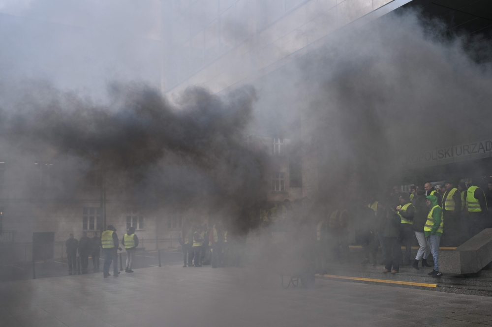 Smoke from flares is seen in front of the Greater Poland government office building in Poznan, Poland, on February 9, 2024, during a protest of Farmers across the country. (Photo by Sergei GAPON / AFP)
