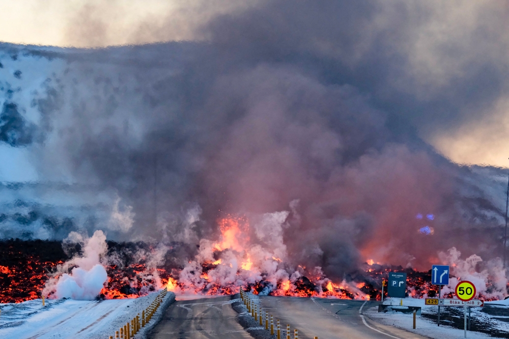Molten lava is seen overflowing the road leading to the famous tourist destination 