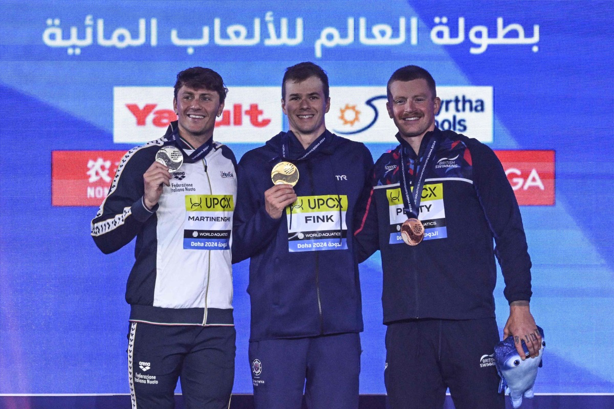Gold medallist US’ Nic Fink (centre), silver medallist Italy’s Nicolo Martinenghi (left) and bronze medallist Britain’s Adam Peaty pose on the podium of the men’s 100m breaststroke yesterday.