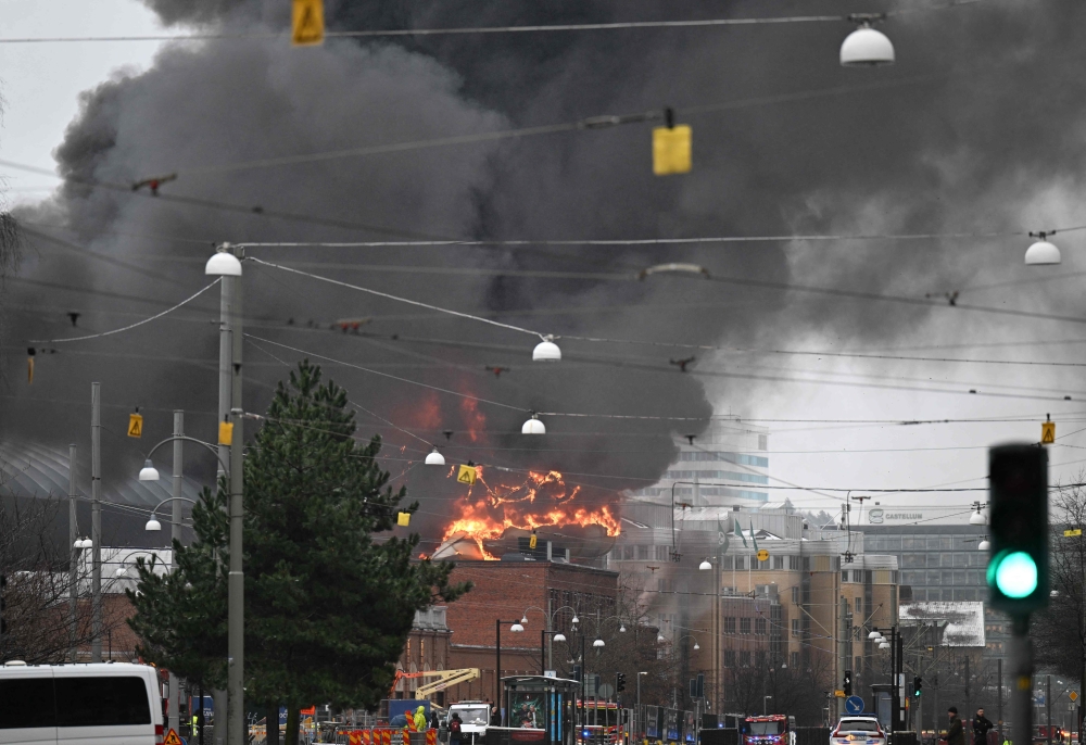 Smoke and flames rise from a building after a fire broke out at the Oceana Waterworld at the Liseberg Amusement Park in Gothenburg, Sweden on February 12, 2024. (Photo by Bjorn LARSSON ROSVALL / TT News Agency / AFP) 