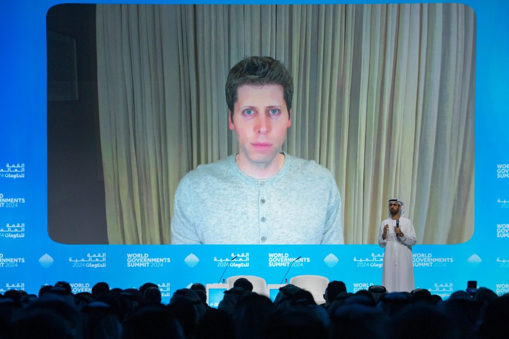 Sam Altman, OpenAI CEO (on screen) speaks in a videocall with Omar al-Olama, Minister of State for Artificial Intelligence, Digital Economy and Remote Work Applications, during the World Government Summit in Dubai on February 13, 2024. (Photo by Ryan LIM / AFP)
