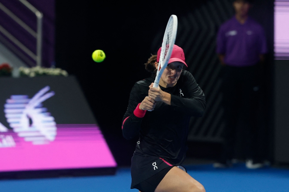 Iga Swiatek of Poland hits a return against Victoria Azarenka of Belarus during their Quarter-Final Women's Singles tennis match at the Qatar WTA Open at Khalifa International Tennis and Squash Complex in Doha on February 15, 2024. (Photo by Karim Jaafar / AFP)