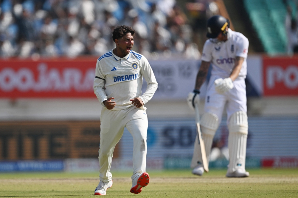 India's Kuldeep Yadav celebrates after the dismissal of England's Ben Duckett during the third day of the third Test cricket match between India and England at the Niranjan Shah Stadium in Rajkot on February 17, 2024. (Photo by Punit Paranjpe / AFP) 