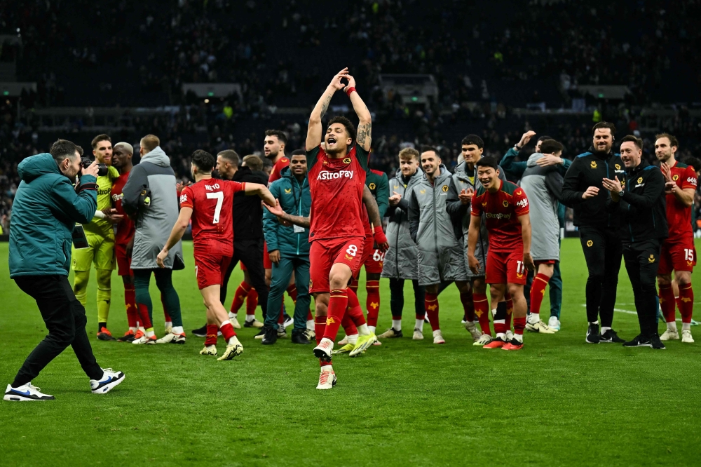 Wolverhampton Wanderers' Brazilian midfielder #08 Joao Gomes (C) celebrates with teammates at the end of the English Premier League football match between Tottenham Hotspur and Wolverhampton Wanderers at the Tottenham Hotspur Stadium in London, on February 17, 2024. (Photo by Ben Stansall / AFP)