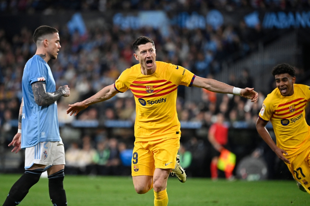 Barcelona's Polish forward #09 Robert Lewandowski celebrates scoring his team's first goal during the Spanish league football match between RC Celta de Vigo and FC Barcelona at the Balaidos stadium in Vigo on February 17, 2024. (Photo by MIGUEL RIOPA / AFP)
