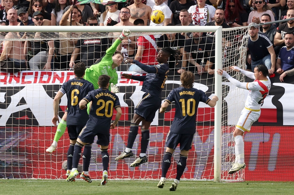 Real Madrid's Ukrainian goalkeeper #13 Andriy Lunin deflects the ball during the Spanish league football match Rayo Vallecano de Madrid and Real Madrid CF at the Vallecas stadium in Madrid on February 18, 2024. (Photo by Pierre-Philippe MARCOU / AFP)
