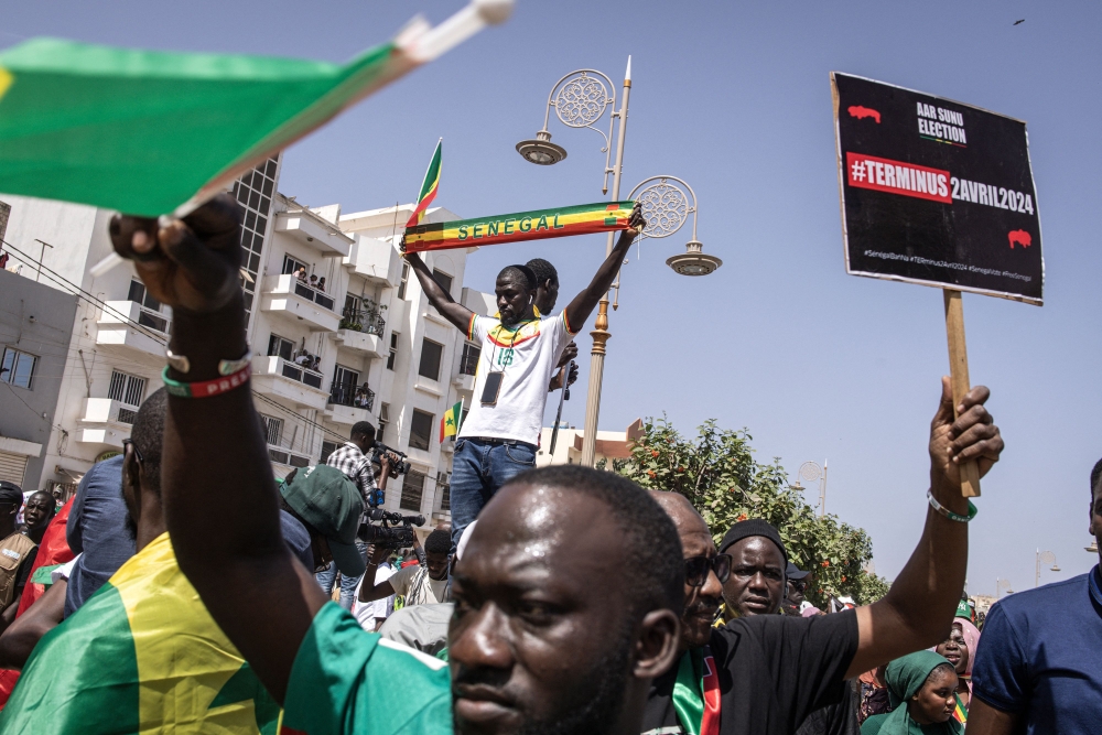 Civil society groups and political groups hold placards as they march calling on authorities respect the election date, in Dakar, on February 17, 2024. (Photo by JOHN WESSELS / AFP)
