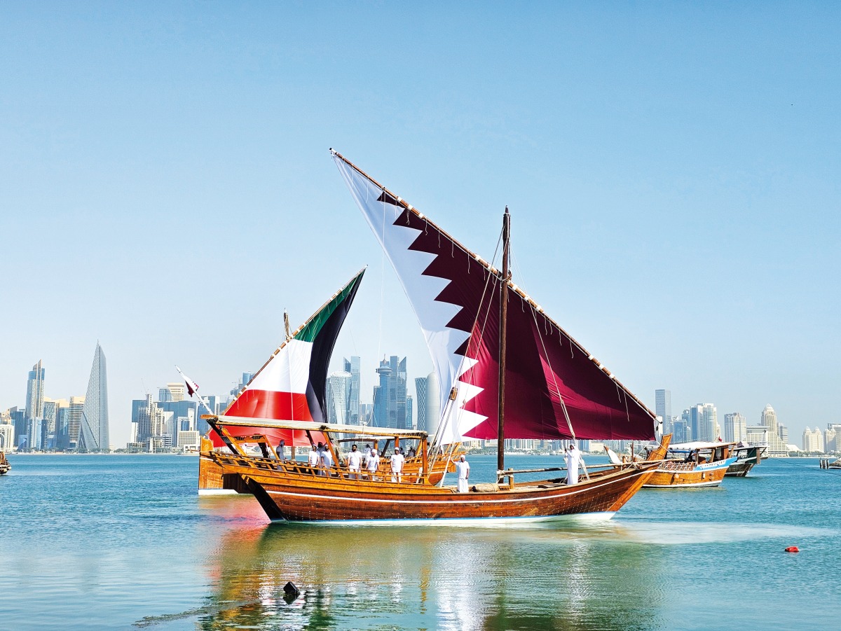 Dhows decorated with Qatari and Kuwaiti flags sail near Doha Corniche promenade. (Pic: Marivie Alabanza / The Peninsula)