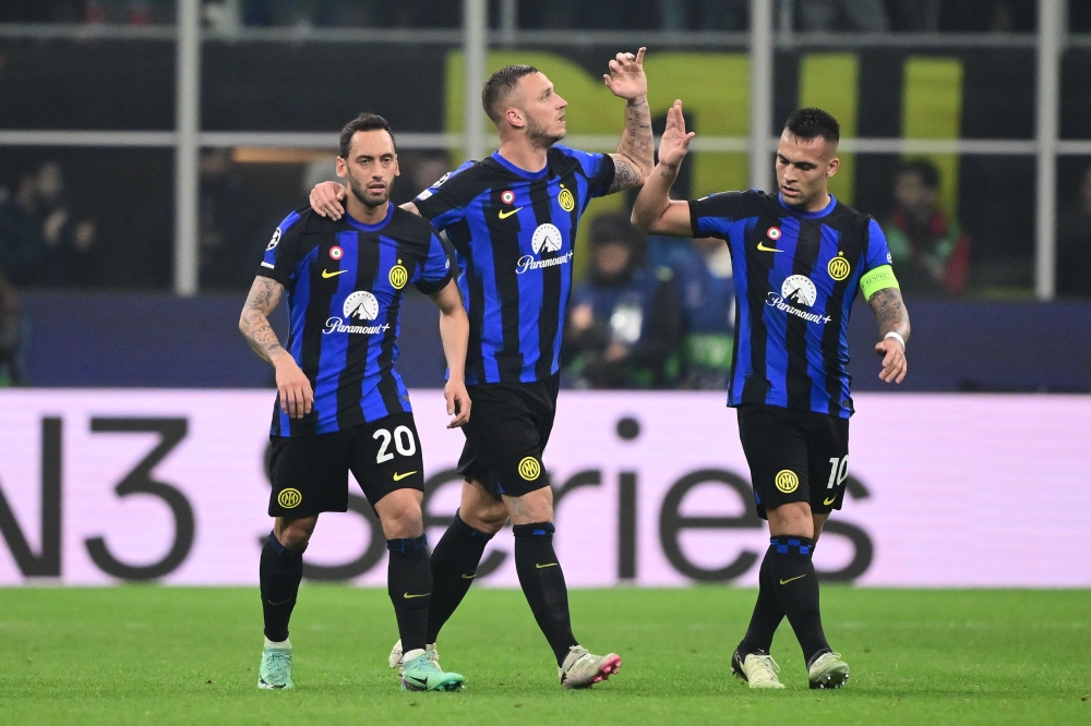 Inter Milan's Turkish midfielder #20 Hakan Calhanoglu, Inter Milan's Austrian forward #08 Marko Arnautovic and Inter Milan's Argentine forward #10 Lautaro Martinez celebrate the team's first goal during the UEFA Champions League last 16 first leg football match Inter Milan vs Atletico Madrid at the San Siro stadium in Milan on February 20, 2024. (Photo by Marco BERTORELLO / AFP)
