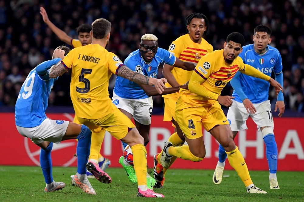 Napoli's Nigerian forward #09 Victor Osimhen (C) vies for the ball during the UEFA Champions League round of 16 first Leg football match between Napoli and Barcelona at the Diego-Armando-Maradona stadium in Naples on February 21, 2024. (Photo by Tiziana FABI / AFP)

