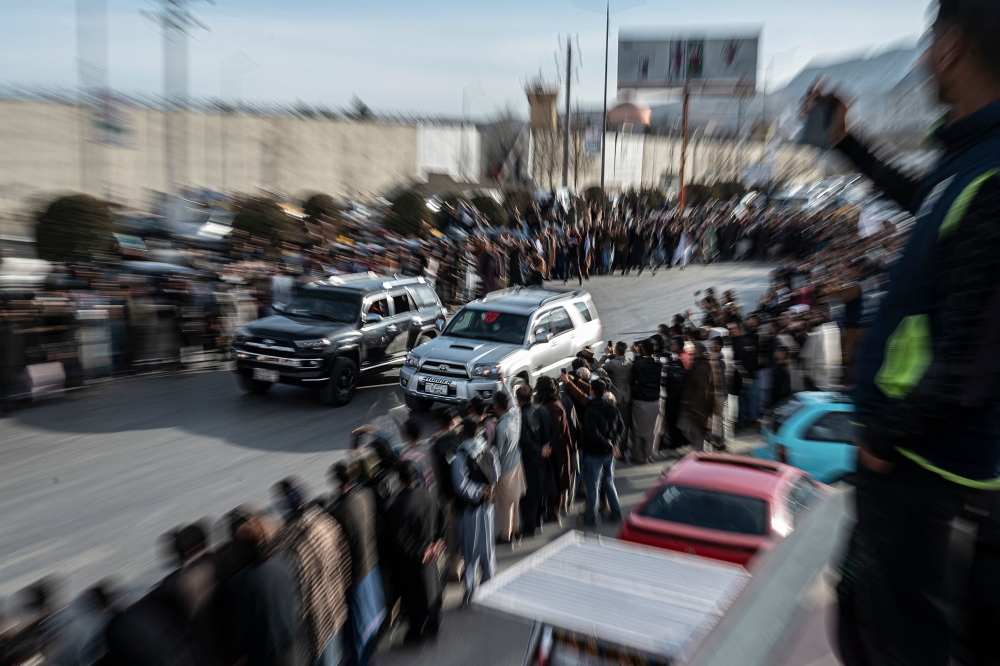 (Files) Spectators watch modified cars compete in a drag race along a street during a car racing event in Kabul on February 16, 2024. (Photo by Wakil Kohsar / AFP)