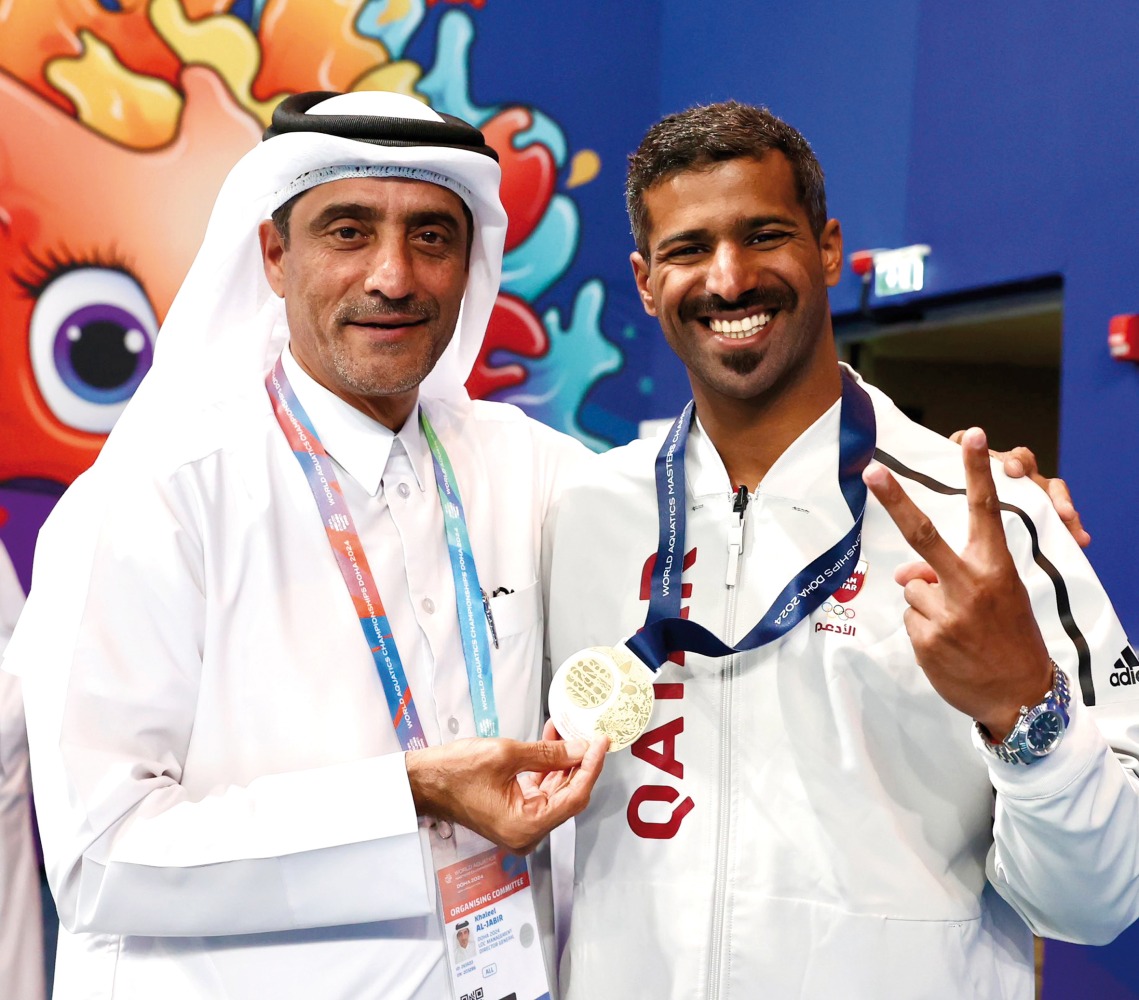 Qatar's Mohammed Shewaiter celebrates his gold medal with Director General of the Doha 2024 Local Organising Committee Khaleel Al Jaber.