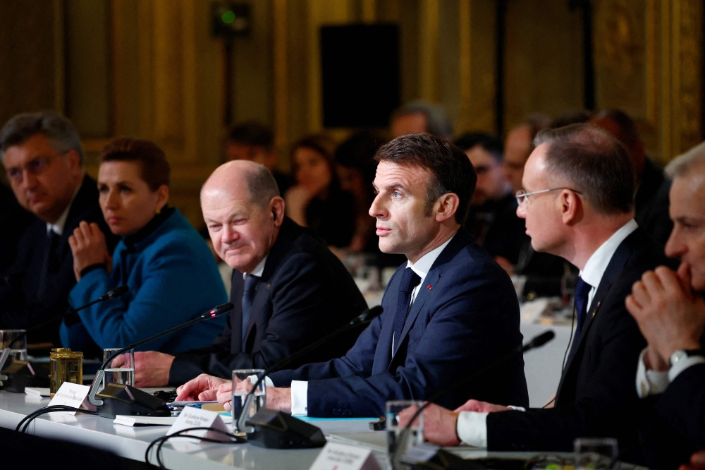 French President Emmanuel Macron, next to Germany's Chancellor Olaf Scholz (L), delivers a speech to open a conference in support of Ukraine with European leaders and government representatives at the Elysee presidential palace in Paris, on February 26, 2024. (Photo by GONZALO FUENTES / POOL / AFP)
