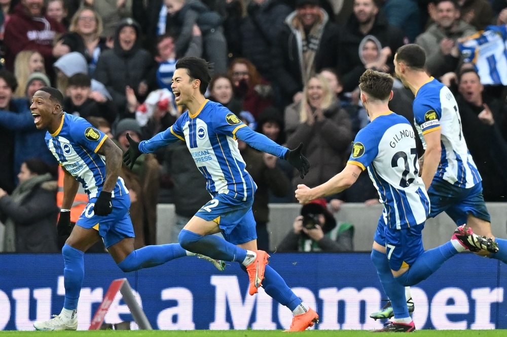 Brighton's Japanese midfielder Kaoru Mitoma (centre) celebrates with teammates after scoring their second goal during the English FA Cup fourth round football match between Brighton & Hove Albion and Liverpool at the Amex stadium in Brighton, on the south coast of England on January 29, 2023. (Photo by Glyn KIRK / AFP)

