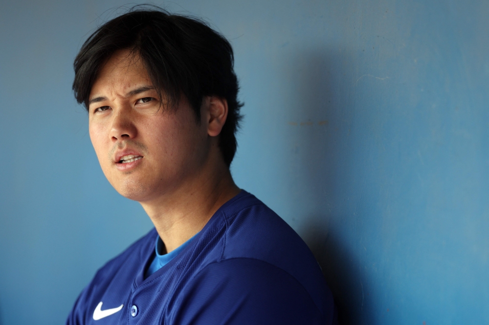 Shohei Ohtani #17 of the Los Angeles Dodgers looks on in the dugout during a game against the Chicago White Sox at Camelback Ranch on February 27, 2024 in Glendale, Arizona. Christian Petersen/Getty Images/AFP