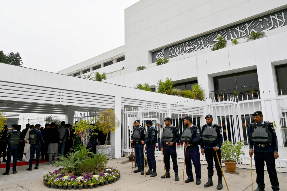 Security personnel stand guard before the start of the inaugural session of the National Assembly after general election, outside the parliament house building in Islamabad on February 29, 2024. (Photo by Farooq Naeem / AFP)