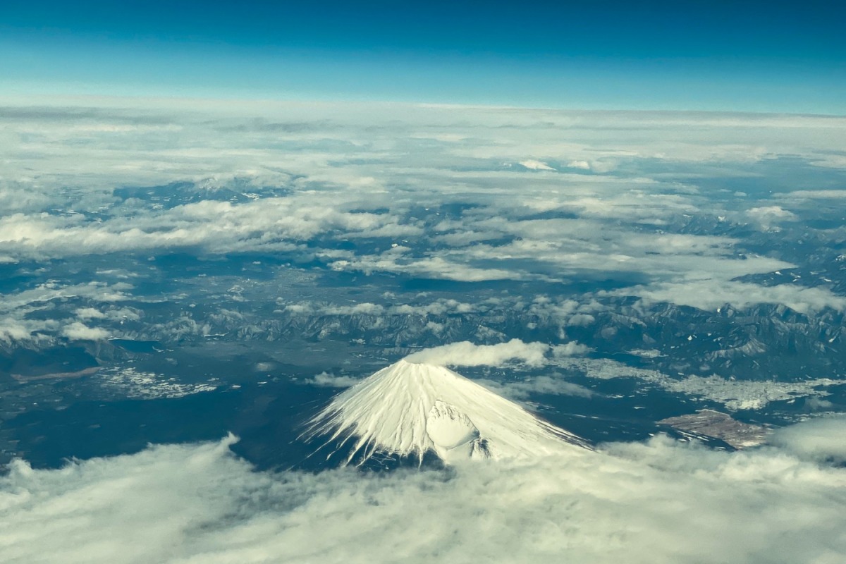 This aerial view of Mount Fuji, Japan's highest peak at 3,776 meters (12,388 feet), is seen from the window of a flight from Tokyo to Hong Kong, above Shizuoka Prefecture on March 1, 2024. (Photo by Philip FONG / AFP)
