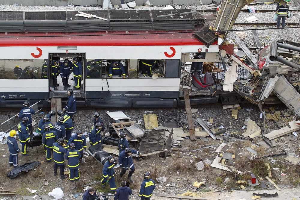 Bodies of victims are evacuated after a train exploded at the Atocha train station in Madrid, on March 11, 2004. Photo by Pierre-Philippe MARCOU / AFP