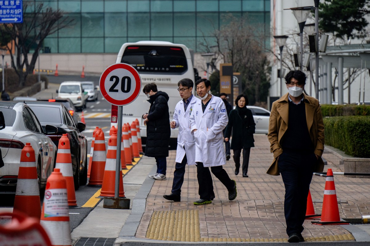 Medical workers walk outside a hospital in Seoul on February 29, 2024. (Photo by Anthony WALLACE / AFP)
