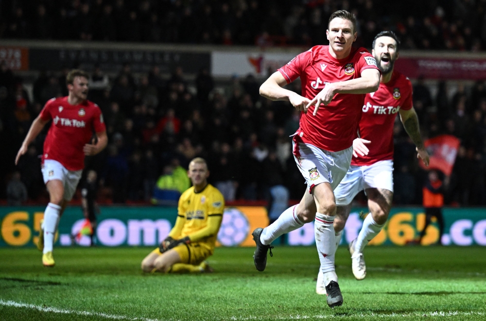 Wrexham's striker Paul Mullin (second right) celebrates scoring the team's third goal during the English FA Cup fourth round match between Wrexham and Sheffield United at the Racecourse Ground Stadium in Wrexham, north Wales, on January 29, 2023. (Photo by Oli SCARFF / AFP)


