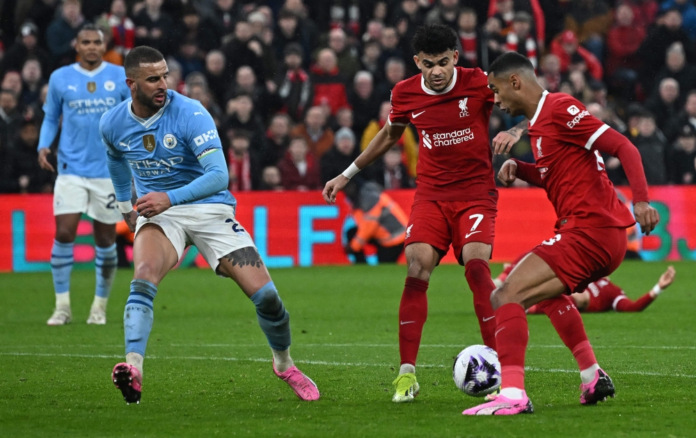 Liverpool's Colombian midfielder #07 Luis Diaz (C) and Liverpool's Dutch striker #18 Cody Gakpo (R) appear to get in each others way during the English Premier League football match between Liverpool and Manchester City at Anfield in Liverpool, north west England on March 10, 2024. (Photo by Paul ELLIS / AFP)