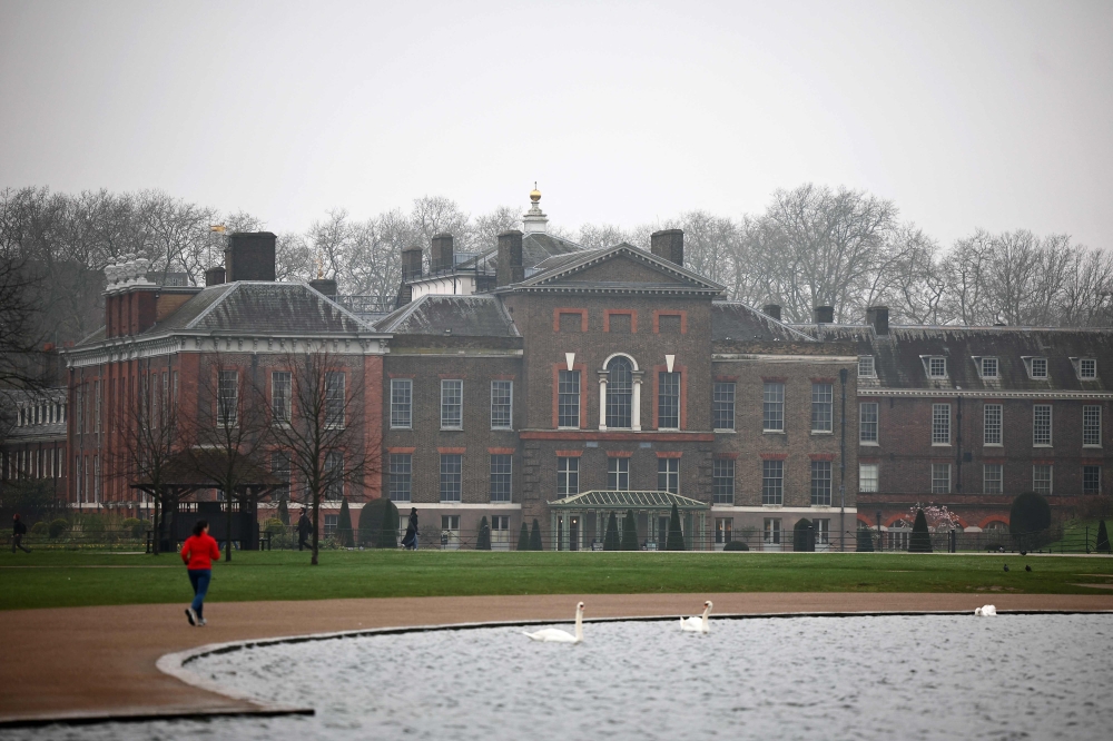 A jogger runs past Kensington Palace in London on March 11, 2024. (Photo by HENRY NICHOLLS / AFP)
