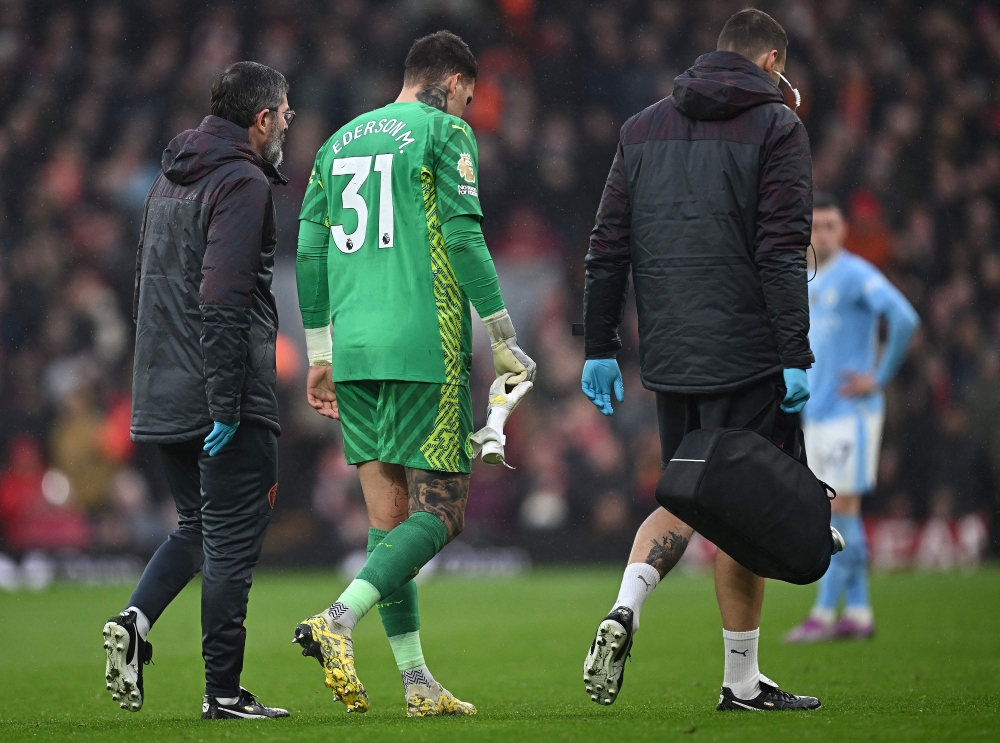 Manchester City's Brazilian goalkeeper #31 Ederson leaves the pitch after being substituted off injured during the English Premier League football match between Liverpool and Manchester City at Anfield in Liverpool, north west England on March 10, 2024. (Photo by Paul ELLIS / AFP)